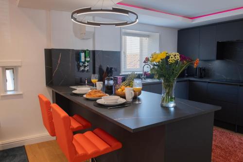 a kitchen with a table with a vase of flowers at The Hayloft, Sewerby, Bridlington, Wi-Fi & Parking in Bridlington