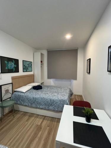 a bedroom with a bed and a large screen at Estrela da Almada Mascarenhas in Almada
