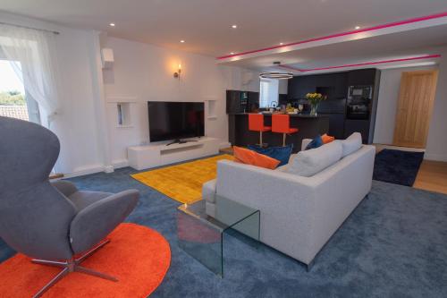 a living room with a white couch and a television at The Hayloft, Sewerby, Bridlington, Wi-Fi & Parking in Bridlington