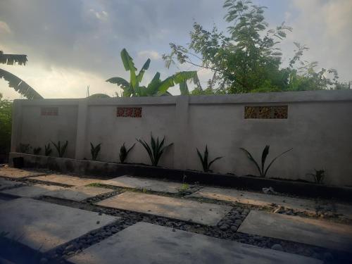 a white fence with plants in front of it at Ayunda Stay & Hostel in Airsatang