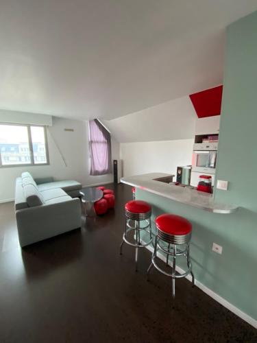 a living room with a couch and two red stools at American Diner 50s in Savigny-sur-Orge