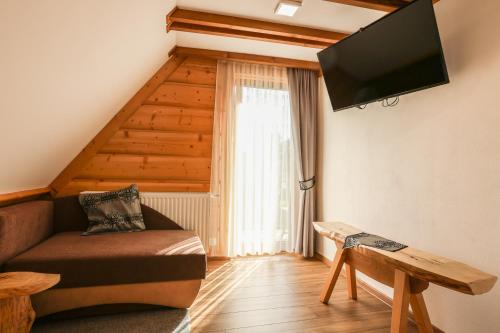 a living room with a couch and a flat screen tv at Apartamenty Willa Anna in Poronin