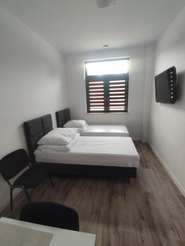 a small room with two beds and a window at Hostel Krańcowa in Ostrołęka