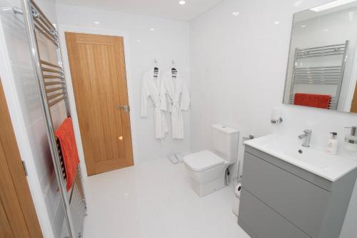 une salle de bain blanche avec toilettes et lavabo dans l'établissement The Hayloft, Sewerby, Bridlington, Wi-Fi & Parking, à Bridlington