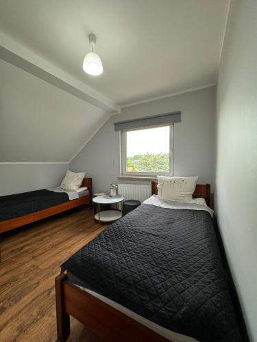 a bedroom with two beds and a window at Milena -Noclegi in Pożrzadło
