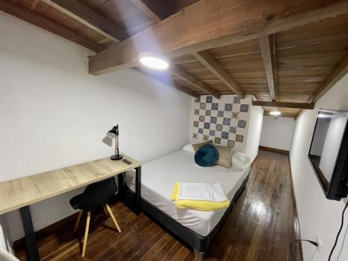a small room with a bed and a desk at apartamento duplex con balcon y vista a la represa in Guatapé