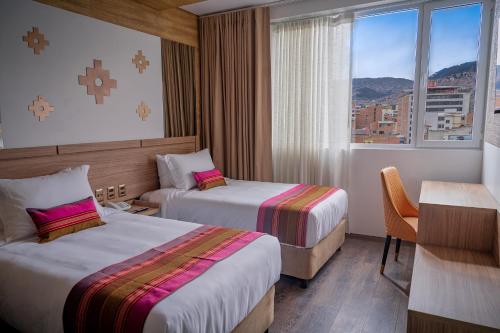 ラパスにあるIllampu Art Boutique Hotelのベッドが2つと窓があるホテルの部屋