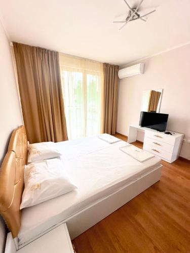 a bedroom with a large white bed and a window at Long Sunny Holiday in Shkorpilovtsi