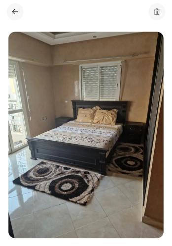 a bed in a room with two rugs at Dar mayssane in Agadir