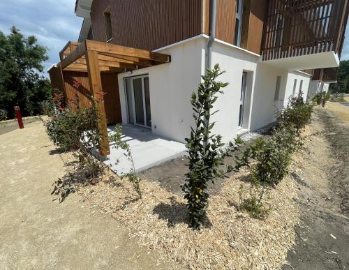 un bâtiment avec un arbre devant lui dans l'établissement T2 neuf proche ocean, à Messanges