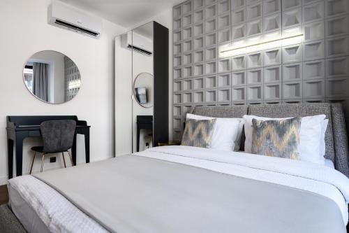 a bedroom with a large white bed and a desk at URBAN DOWNTOWN luxury rooms and suites in Belgrade