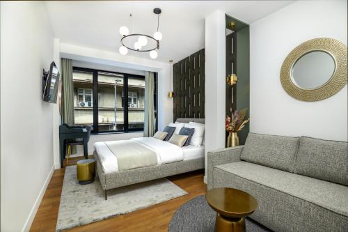 a bedroom with a bed and a couch at URBAN DOWNTOWN luxury rooms and suites in Belgrade