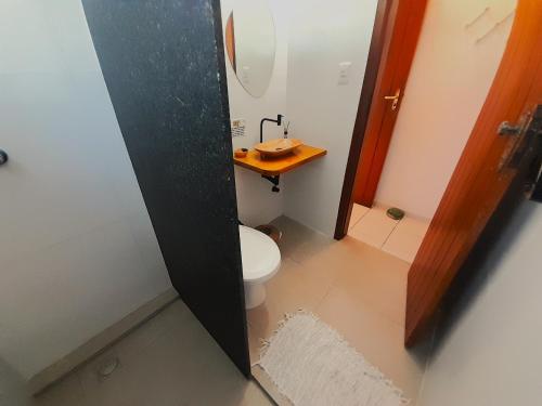 a small bathroom with a toilet and a sink at Pousada do Rock in Arraial d'Ajuda