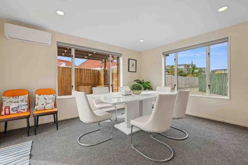 a dining room with a white table and chairs at A Great Location 4 bedrooms, quiet and comfort! in Christchurch