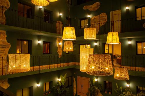 a group of lights hanging from a building at night at Casa Nduxi Puebla Departamentos in Puebla