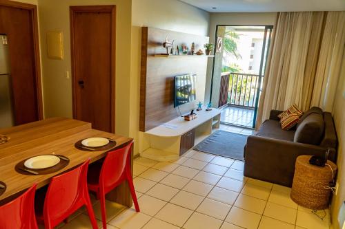 ein Wohnzimmer mit einem Tisch und einem Sofa in der Unterkunft Marulhos Resort - Conforto e Espaço pra curtir e relaxar in Porto De Galinhas