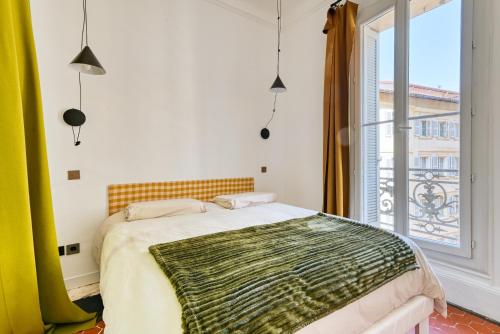 une chambre avec un lit et une grande fenêtre dans l'établissement Joli T4 110m2 au cœur de Marseille, à Marseille