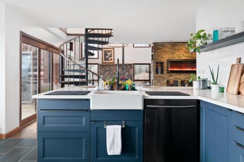 a kitchen with blue cabinets and a sink at 5 Star Gorgeous Cliffside Chalet with Panoramic Views in Tannersville