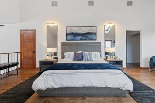 a bedroom with a large bed and two mirrors at 5 Star Gorgeous Cliffside Chalet with Panoramic Views in Tannersville