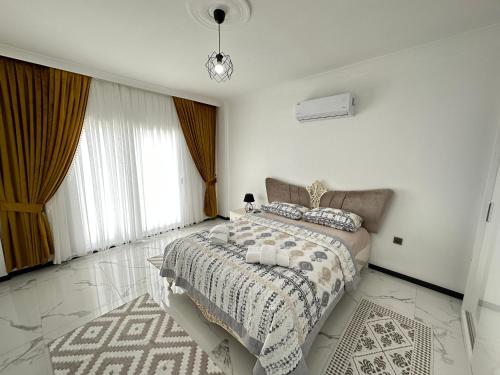a white bedroom with a bed and a large window at Dalyan villa star 1 in Ortaca