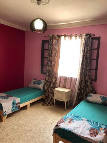 a bedroom with two beds and a window at Sidi fredj in Sidi Ferruch