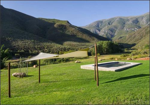 a white umbrella in a field with a pool at Pat Busch Mountain Reserve in Robertson