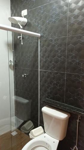 a bathroom with a toilet and a glass shower at Segunda Casa- Seu cantinho na Praia do Morro em Guarapari - Quartos suítes 2 até 4 pessoas in Guarapari