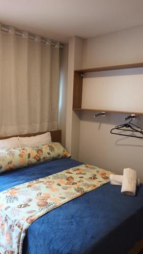 a bedroom with a bed with a blanket on it at Segunda Casa- Seu cantinho na Praia do Morro em Guarapari - Quartos suítes 2 até 4 pessoas in Guarapari