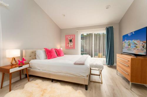 een slaapkamer met een groot bed en een televisie bij Casa Marilyn in Palm Springs