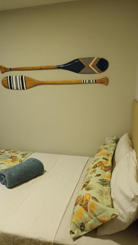 a bed with a wooden headboard hanging on a wall at Segunda Casa- Seu cantinho na Praia do Morro em Guarapari - Quartos suítes 2 até 4 pessoas in Guarapari