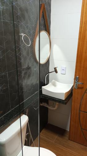a bathroom with a sink and a mirror at Segunda Casa- Seu cantinho na Praia do Morro em Guarapari - Quartos suítes 2 até 4 pessoas in Guarapari