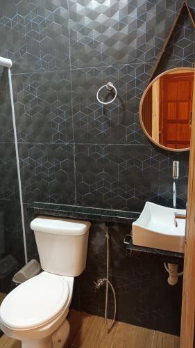 a bathroom with a toilet and a sink at Segunda Casa- Seu cantinho na Praia do Morro em Guarapari - Quartos suítes 2 até 4 pessoas in Guarapari
