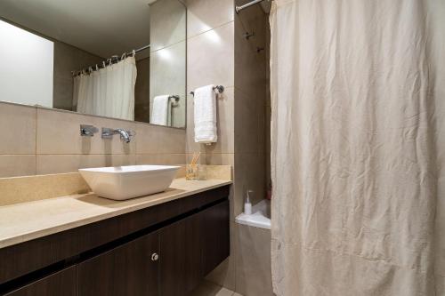 Un baño con lavabo y cortina de ducha. en Moderno y cálido estudio en Recoleta, en Buenos Aires