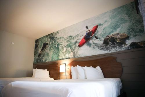a hotel room with two beds and a painting on the wall at The Inn At Tree City, BW Signature Collection in McMinnville