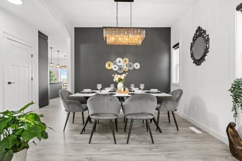 a dining room with a table and chairs at LUXURY LAKEVIEW HOME - 2500sqft of private space with 5 Beds, 4 Bath, 2 Living Rooms, Kitchen, AC, Jacuzzi, 10 Guests Max, Basement Not Included, 18-min to Airport, 20-min to Downtown, 80-min to Banff in Calgary