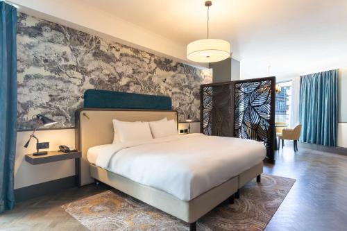 a bedroom with a large white bed and a wall at Radisson Blu Hotel, Glasgow in Glasgow