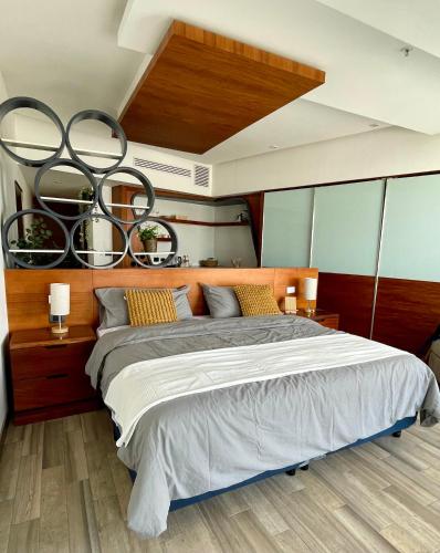 a bedroom with a large bed with a wooden headboard at Hotel Sonata Angelopolis in Lomas de Angelopolis