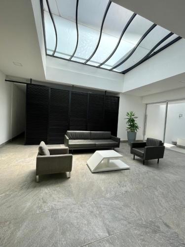 a living room with couches and chairs and a skylight at Hotel Sonata Angelopolis in Lomas de Angelopolis