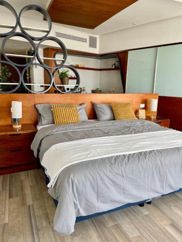 a bedroom with a large bed and two lamps at Hotel Sonata Angelopolis in Lomas de Angelopolis