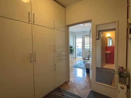 a kitchen with white cabinets and a doorway into a room at Apartman “Sofia” in Pirot