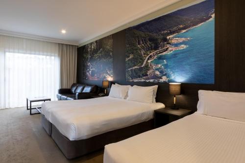 a hotel room with two beds and a couch at Mercure Gerringong Resort in Gerringong
