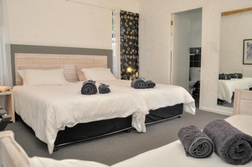 a bedroom with two beds with towels on them at Puza Moya Guest House in Langebaan