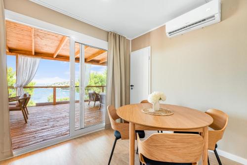 a dining room with a table and a balcony at Luce mobile homes L1, L2, L3 in Drage