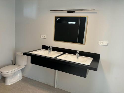 a bathroom with two sinks and a toilet at Toahotu koakoa lodge presqu'île tahiti in Tohautu