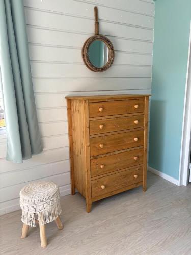 a wooden dresser with a mirror and a stool at Toahotu koakoa lodge presqu'île tahiti in Tohautu