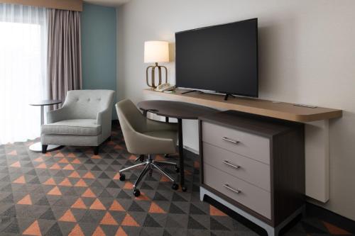 a room with a desk with a television and a chair at Holiday Inn Portland - Columbia Riverfront by IHG in Portland