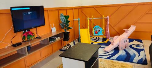 a living room with a flat screen tv and a toy at Hayyan Homestays in Kuantan