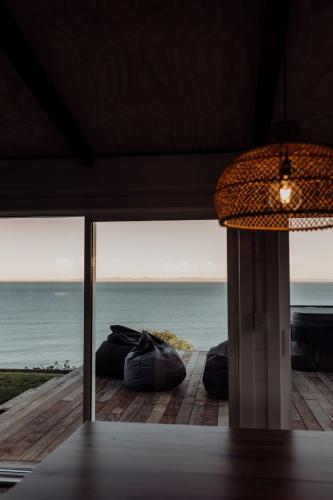 a room with a view of the ocean from a house at Ocean View Bach in Motunau