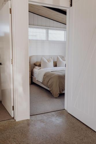 a bedroom doorway with a bed in a room at Ocean View Bach in Motunau