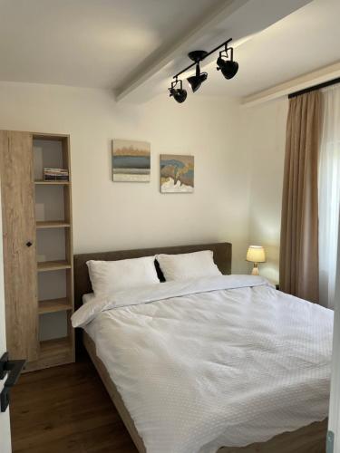 a bedroom with a large bed with white sheets at Bungalovi izvor Plive 3 in Šipovo